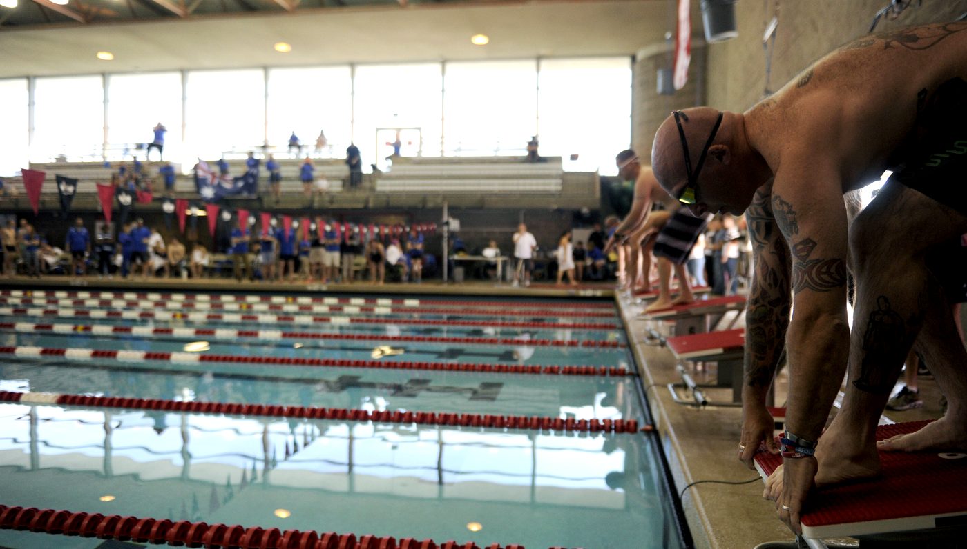 Masters swimmers set on the starting blocks at an indoor pool